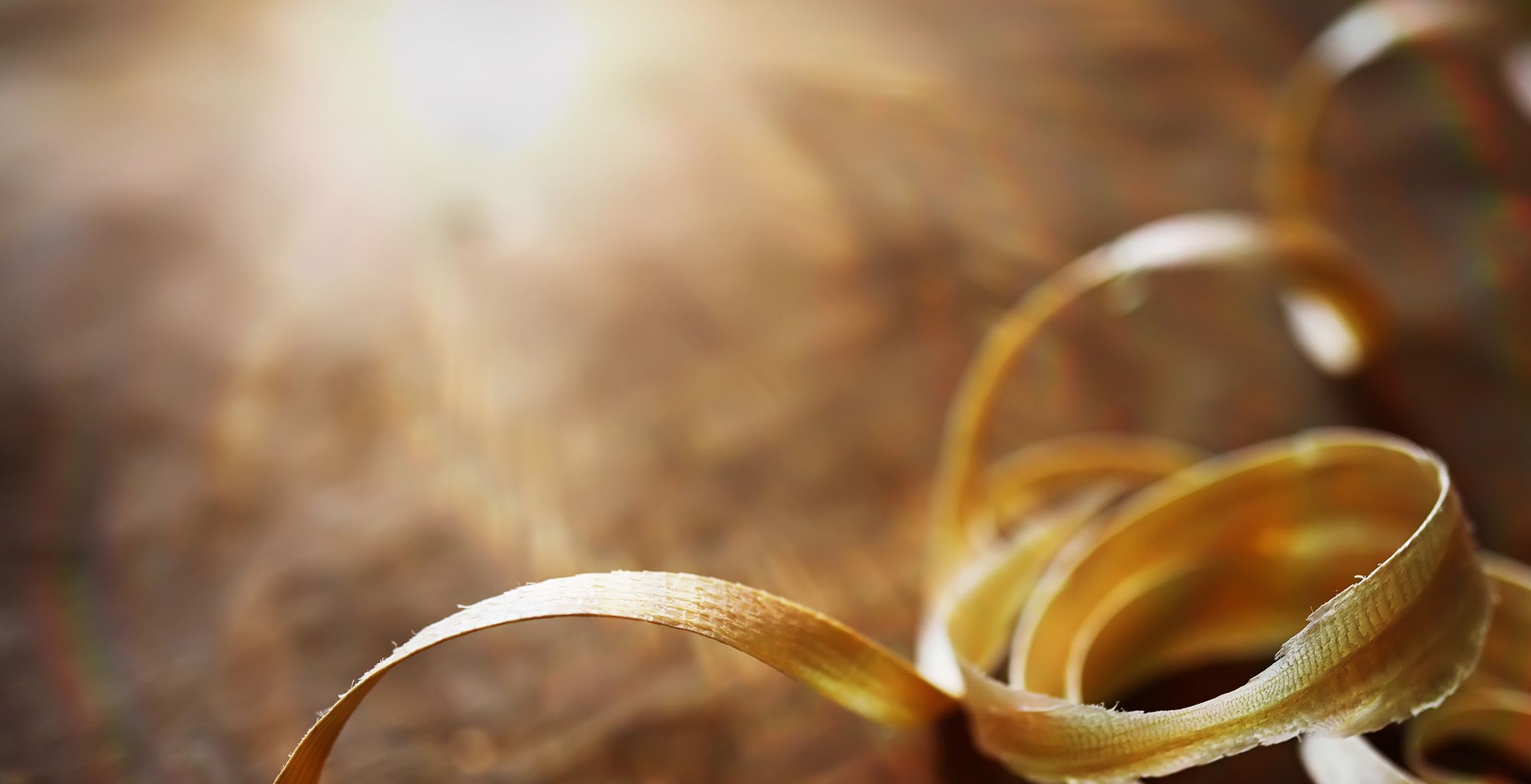 Goldenes Band auf einem Holztisch, durch das Sonnenlicht beleuchtet.