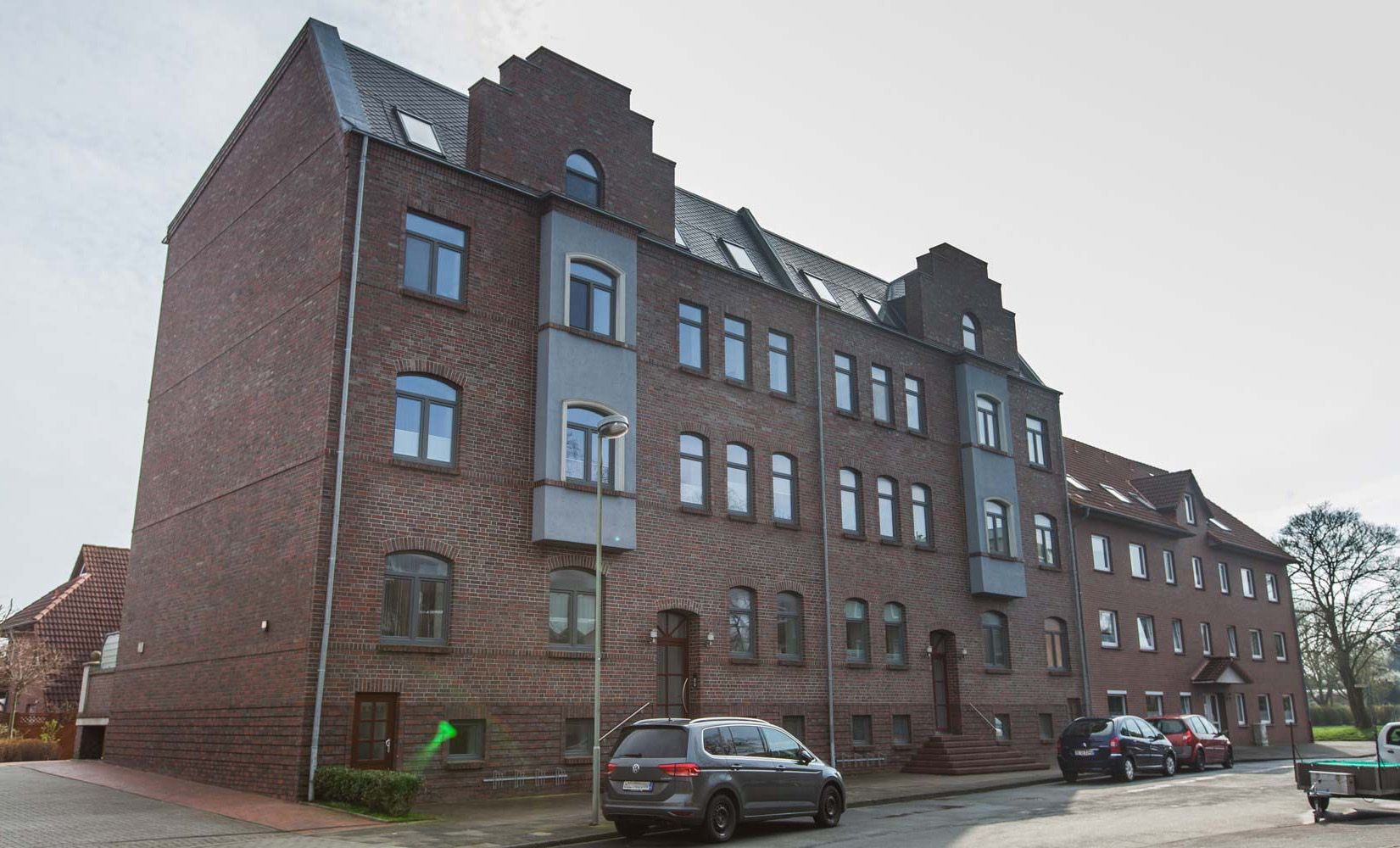 Großes Backsteingebäude mit zahlreichen Fenstern, das eine moderne Architektur ausstrahlt.