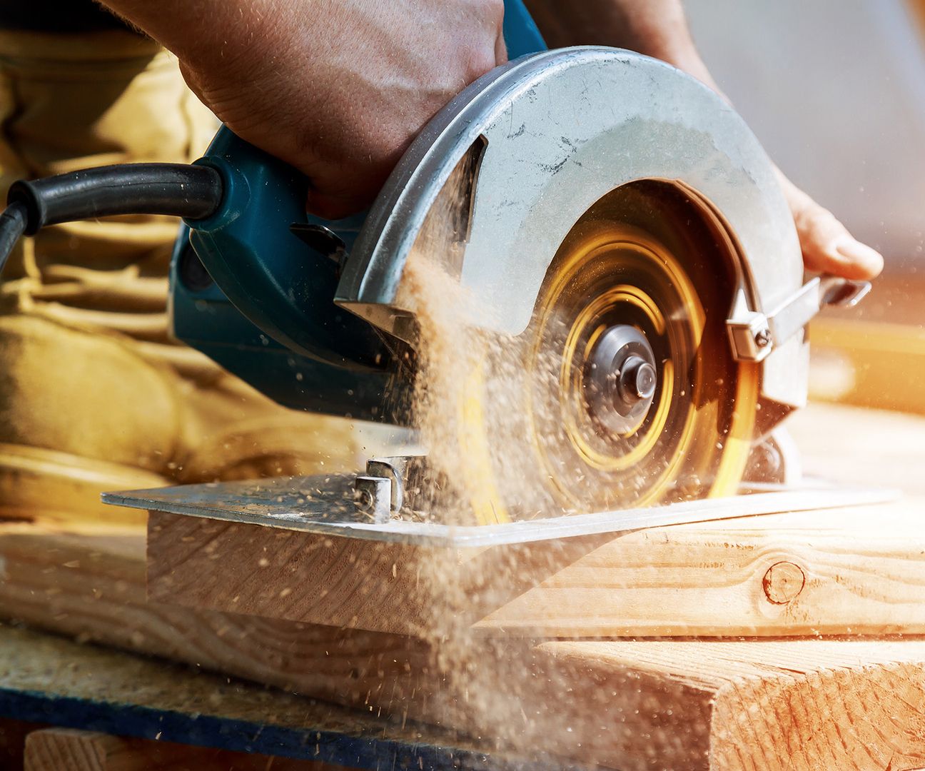 Eine Person verwendet eine Kreissäge, um Holz zu schneiden, während sie sicherheitsbewusst arbeitet.